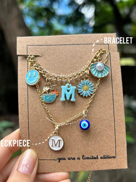 Oceanic Charm Stack: Blue bracelet and necklace with personalized initial, smiley charm, coconut water, flower, shell, and evil eye