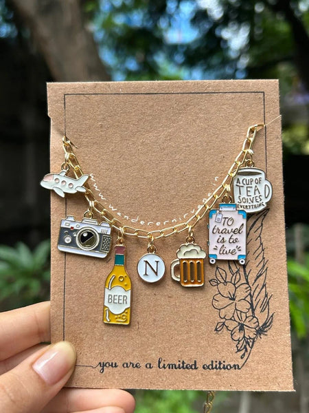 Travel Tales Neckpiece Travel Tales Neckpiece with flight, camera, and personalized initial charms Handcrafted Travel Tales Neckpiece